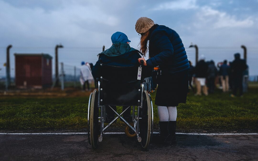 A person learning down to talk to someone in a wheelchair