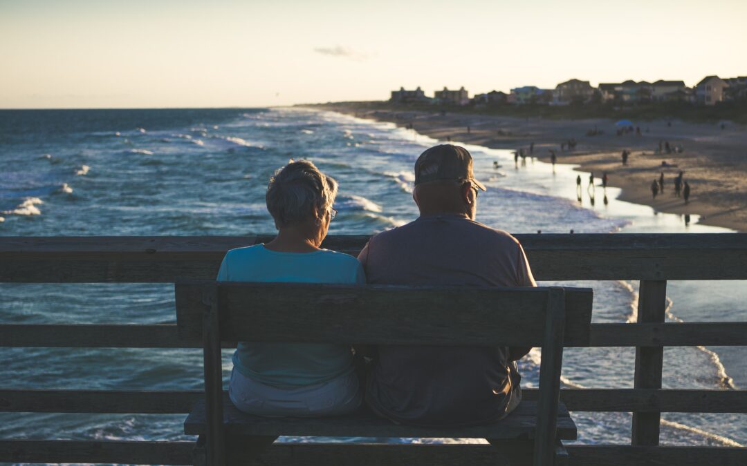 A senior couple sitting on a bench.